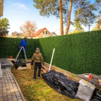 Монтаж зеленого декоративного паркану на сітці рабиця