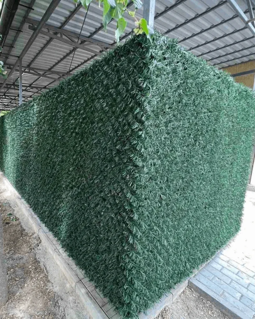 Темно зелений декоративний паркан із штучної хвої на сітці рабиця кут огорожі