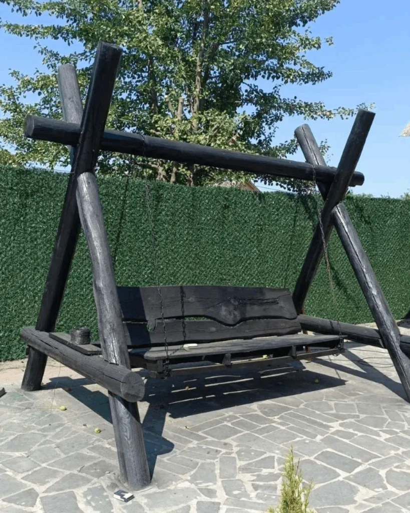 Темно зелений паркан із штучної хвої на сітці рабиця біля зони відпочинку