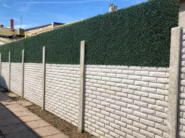 Збільшення висоти бетонного паркану за допомогою декоративної огорожі зі штучної хвої