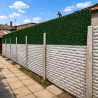 Зелений декоративний паркан встановлений на бетонному заборі