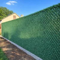 Зелений декоративний паркан на сітці рабиця у саду